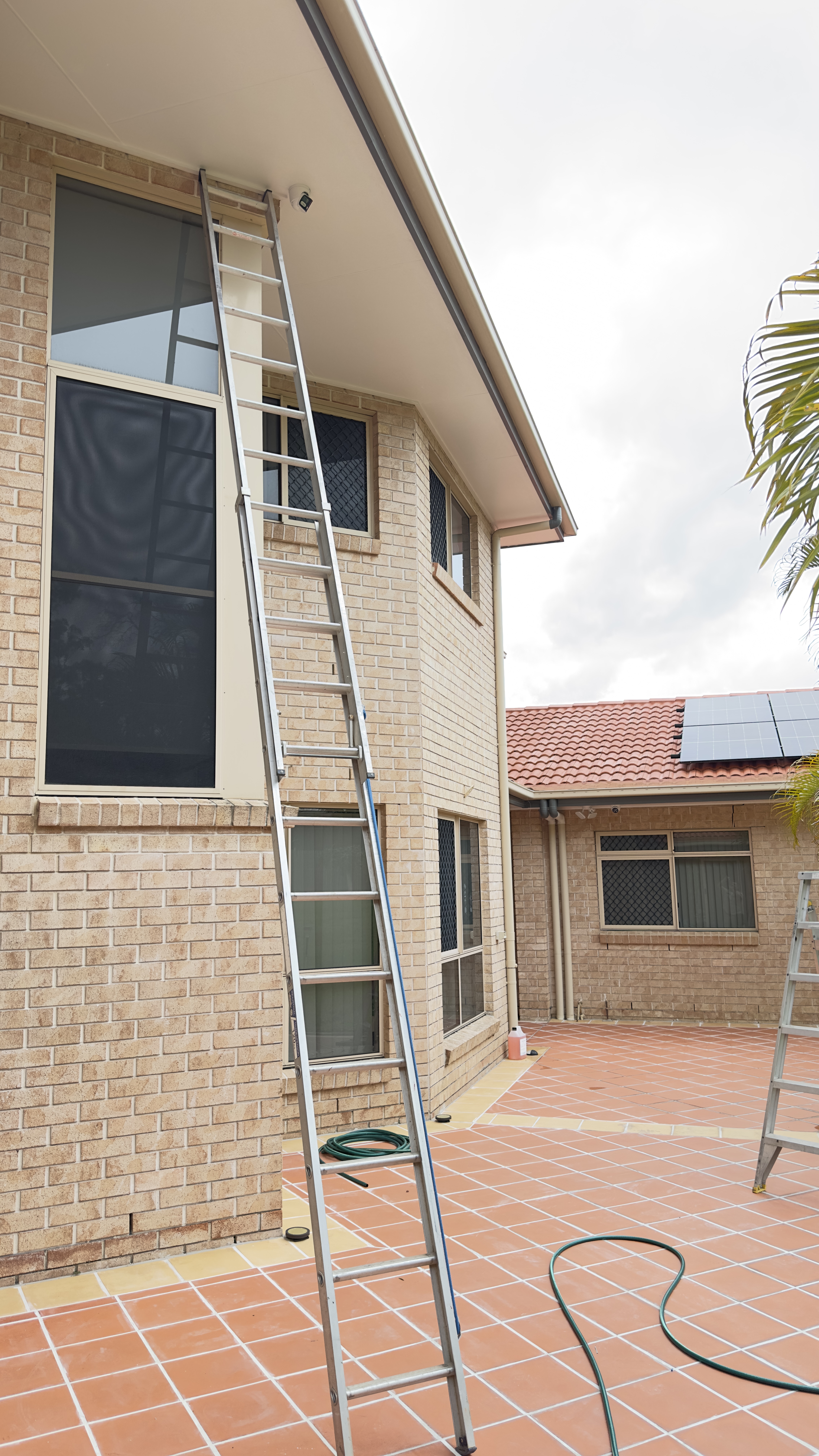Camera installation in progress, ladder on two-storey home
