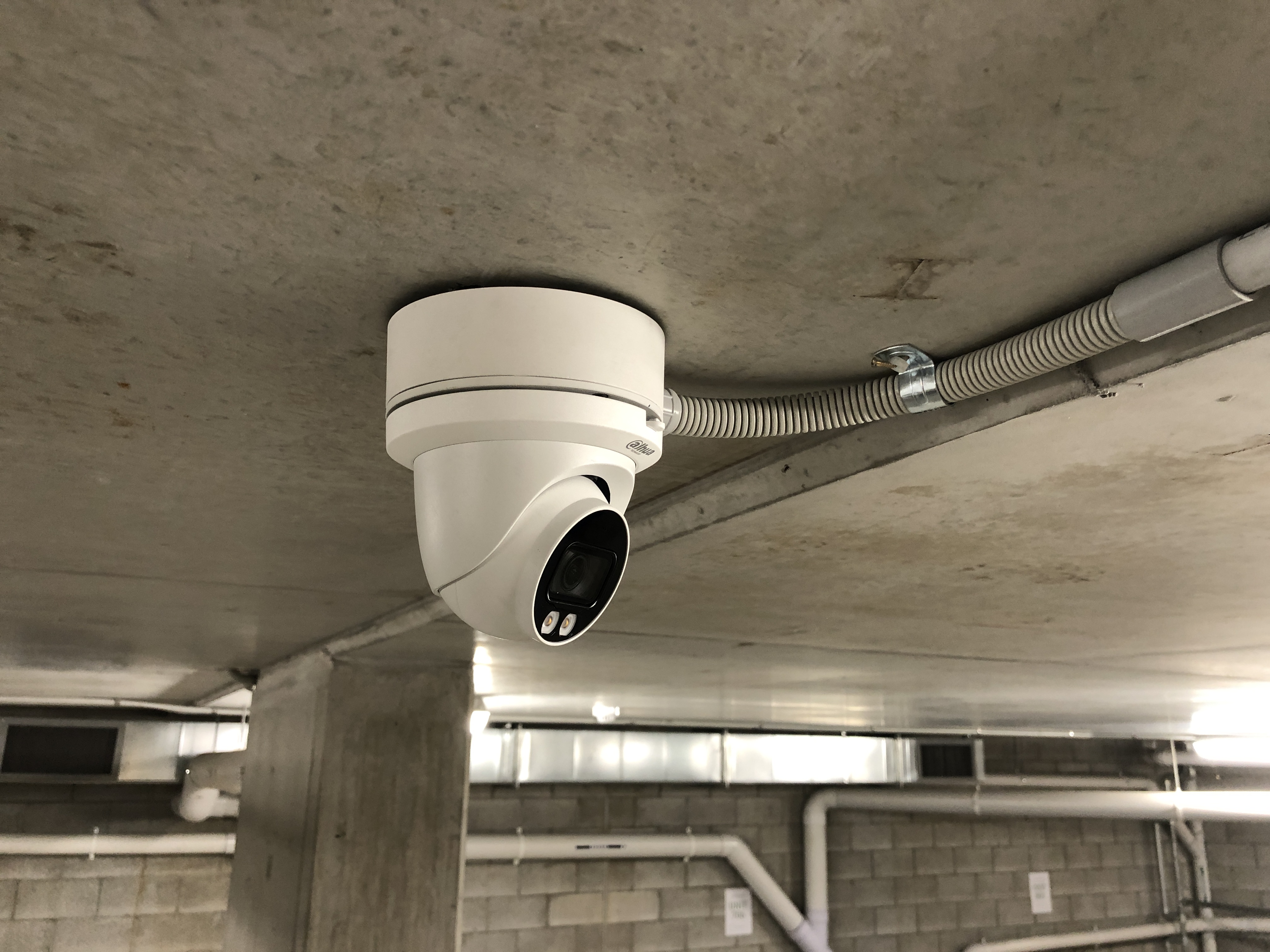 Dahua bullet camera and alarm siren on rendered wall