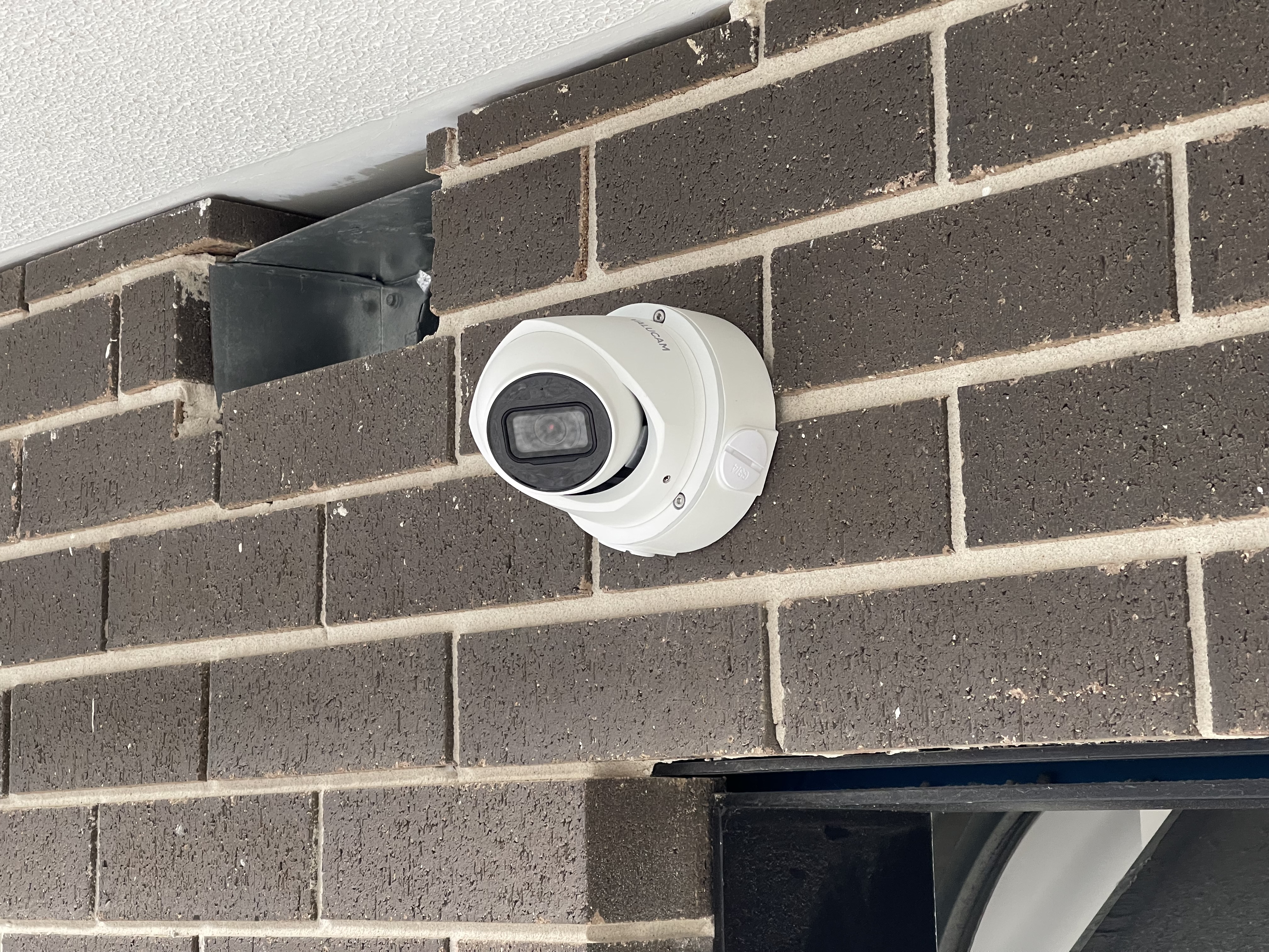 Mini dome camera on brick wall