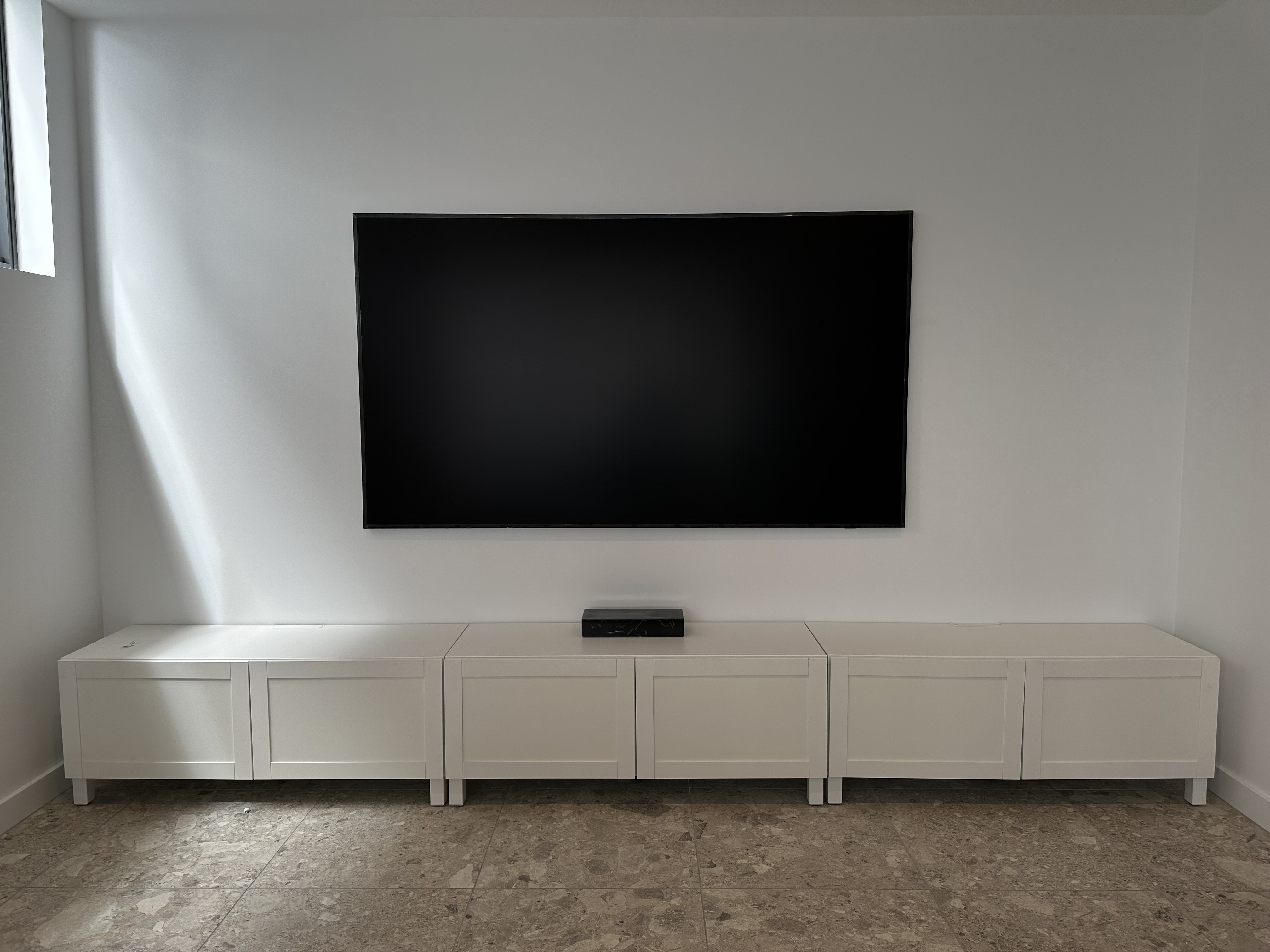 Large TV above white media cabinet